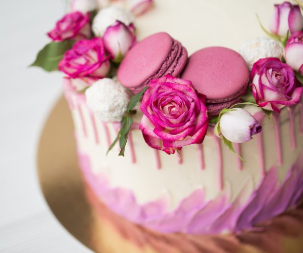 Cake with roses, sweets and lilac macaroons