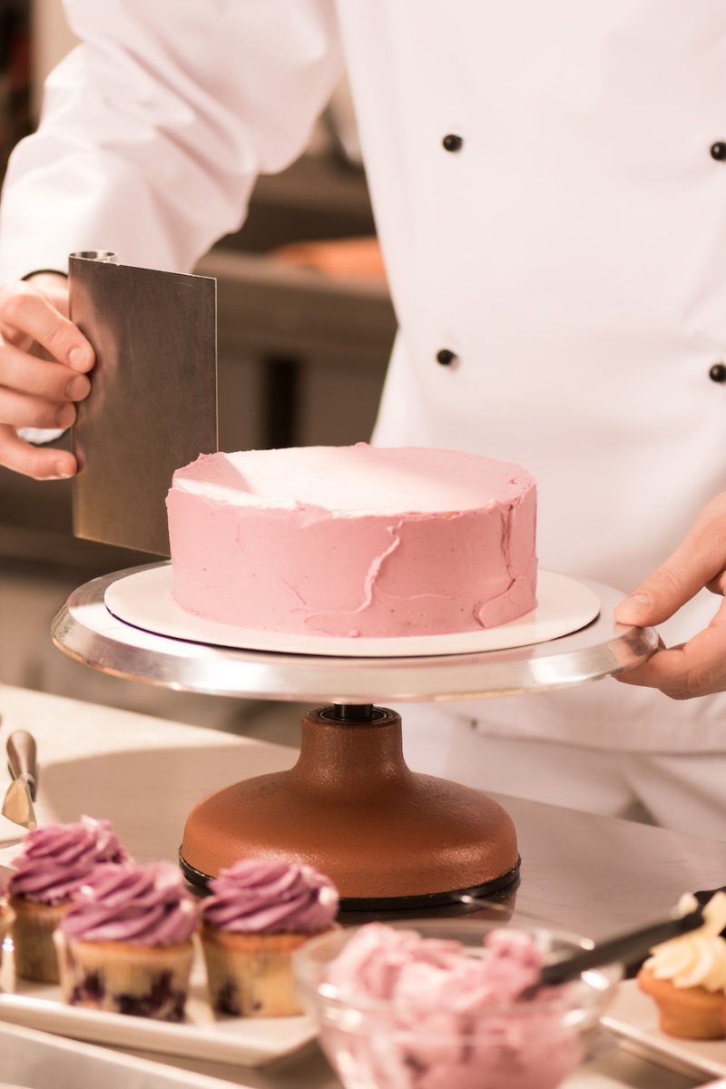 cropped shot of confectioner making cake in restaurant kitchen